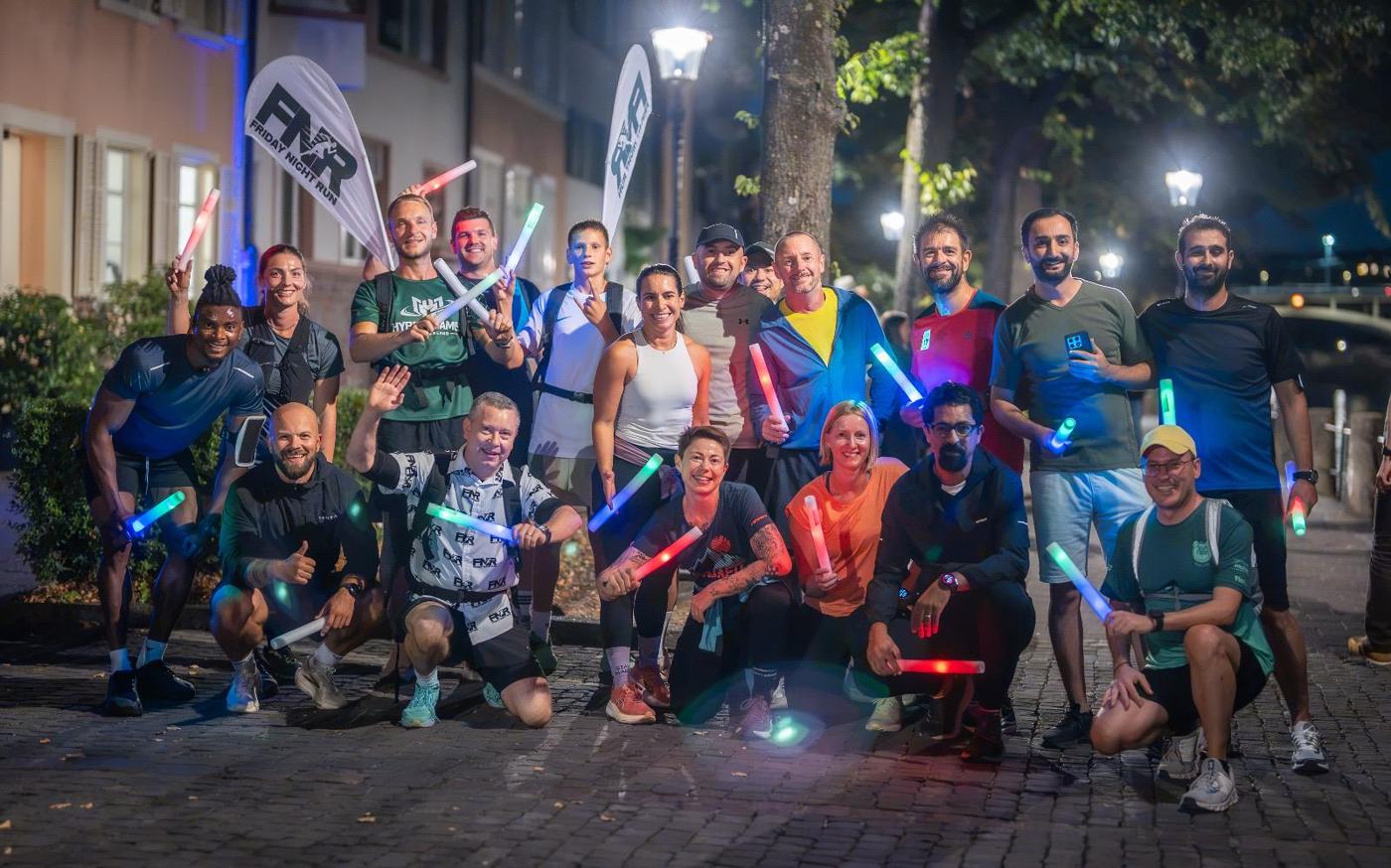 Die Friday Night Run Gemeinschaft mit bunten Leuchtstäben in Basel