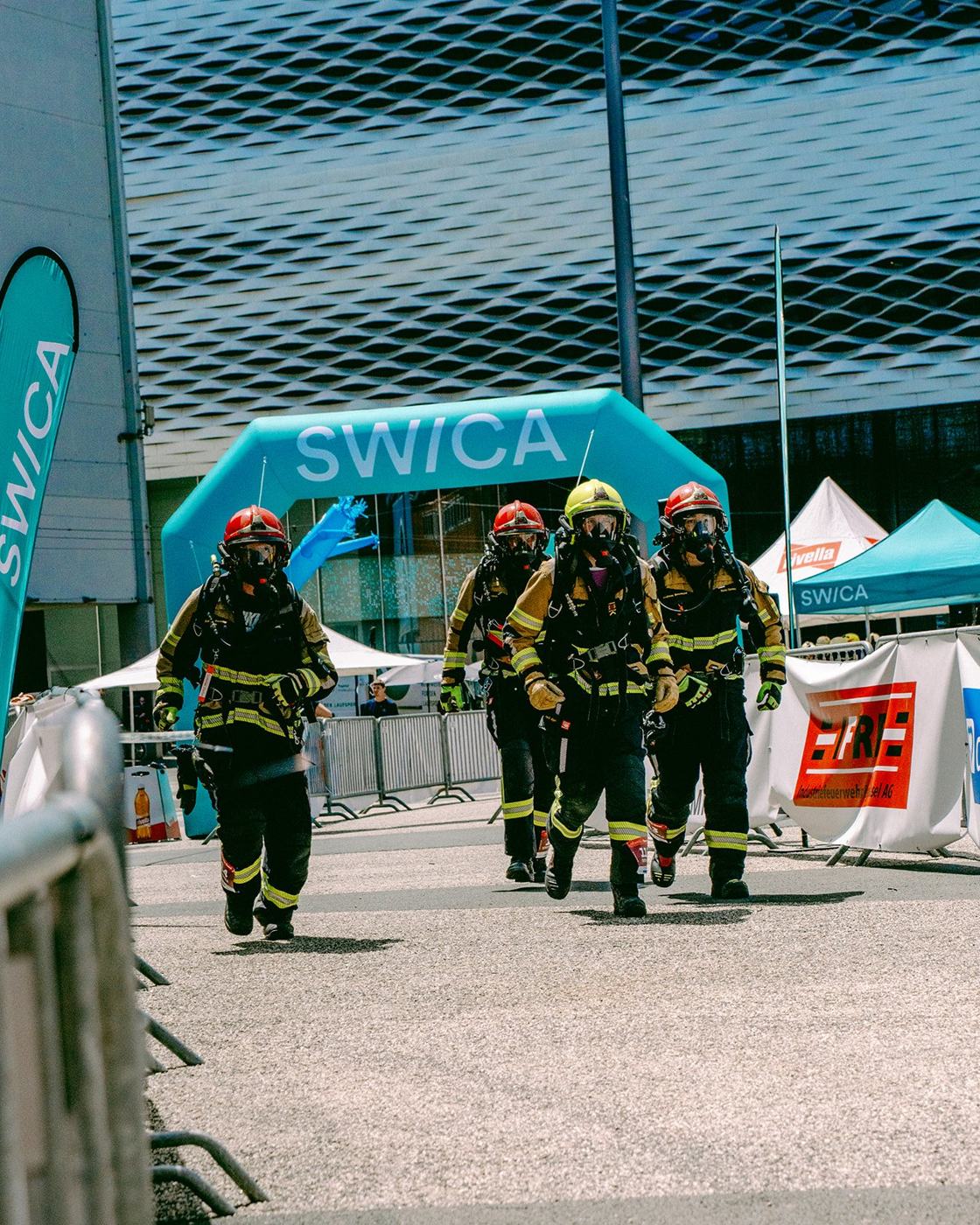 Feuerwehrteam in Einsatzkleidung unter einem Torbogen beim Tower Run