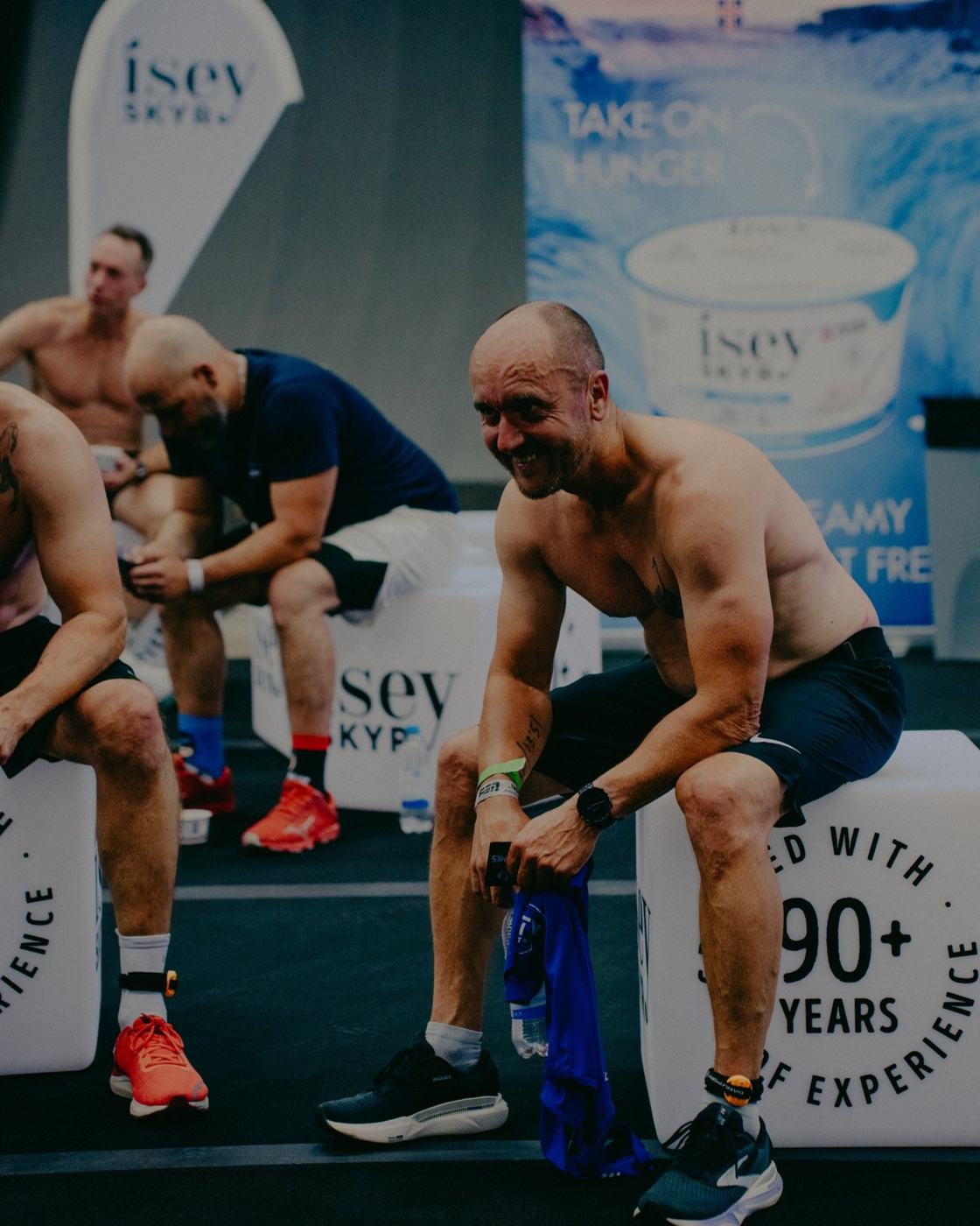 Sportler mit Kettlebells vor einer grossen Markenwerbung