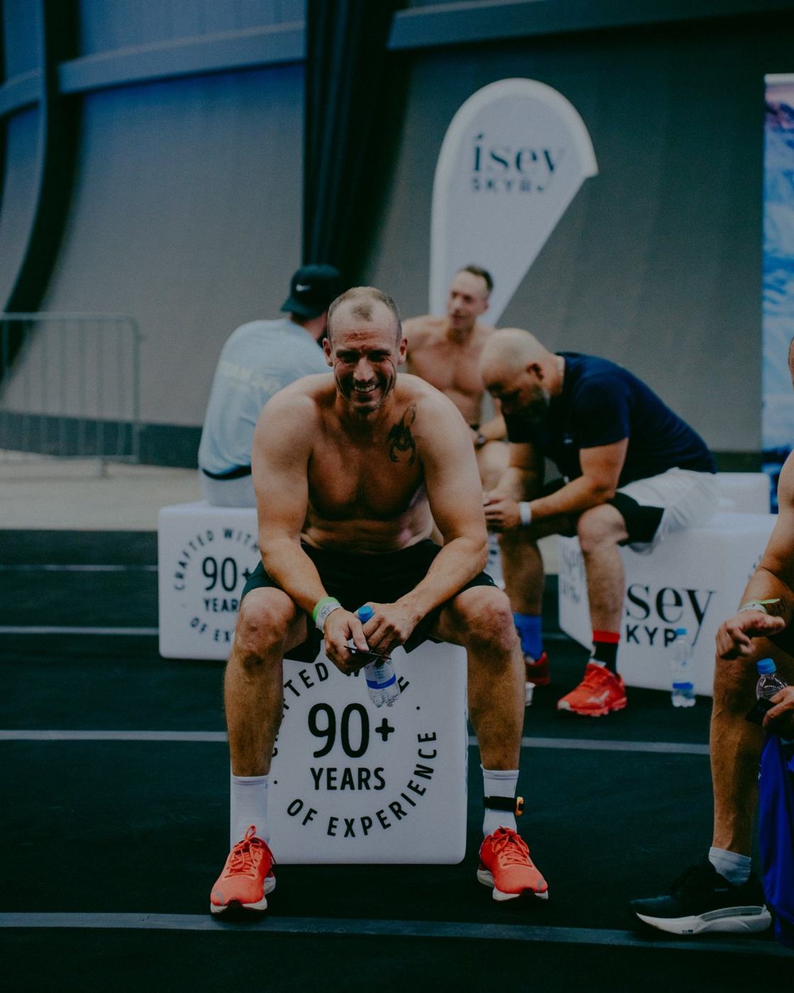 Athlet beim Kettlebell-Tragen vor einer Werbefläche